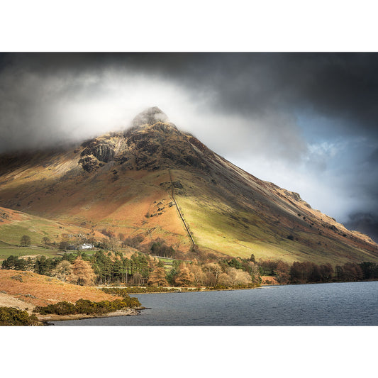 A dramatic landscape showcasing Yewbarrow, Wastwater with sunlight casting shadows on its slopes, adjacent to a calm lake on the Isle of Wight captured by Available Light Photography.