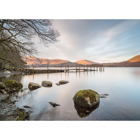 Tranquil Derwent Water scene with a jetty and mountains in the background at dusk by Available Light Photography.