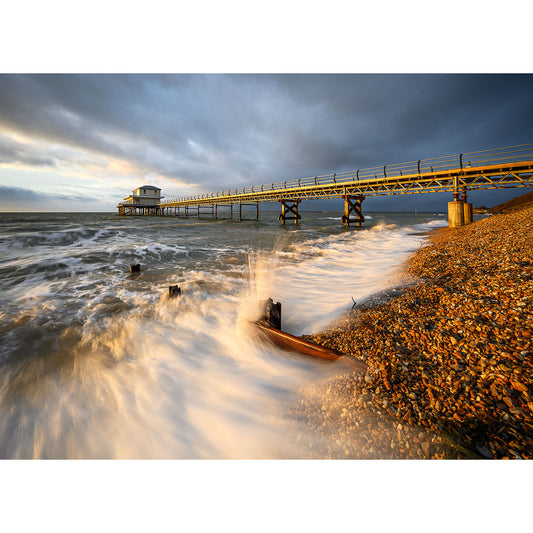 Sunset at Totland Beach on the Isle of Wight with waves crashing ashore and a pier extending into the sea, captured by Available Light Photography.