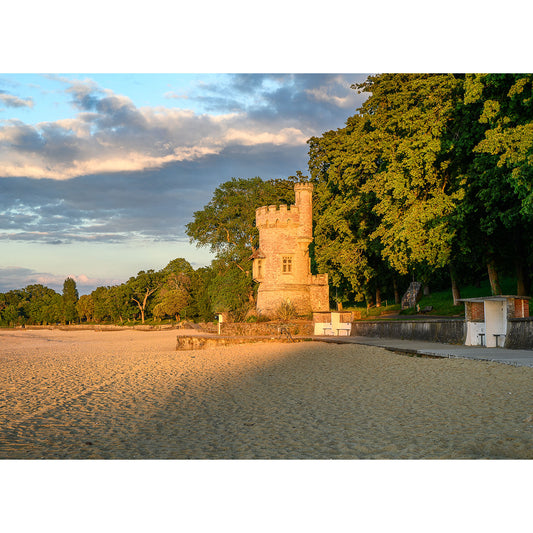 Historic stone Appley Tower bathed in golden hour sunlight on a sandy beach with lush trees in the background, photographed by Steve Gascoigne.
