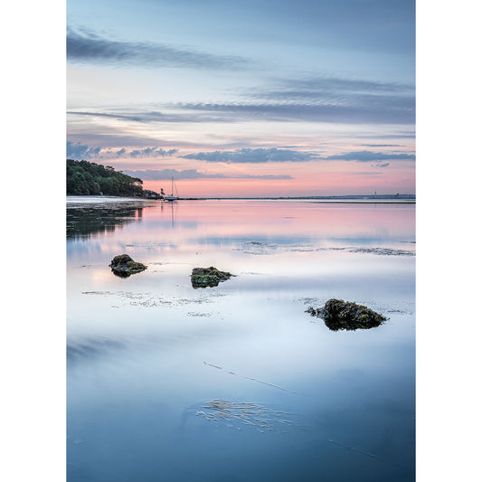 Calm waters at dusk with scattered rocks and a pastel sky reflected on the surface near Gascoigne captured beautifully in the Priory Bay photograph by Available Light Photography.