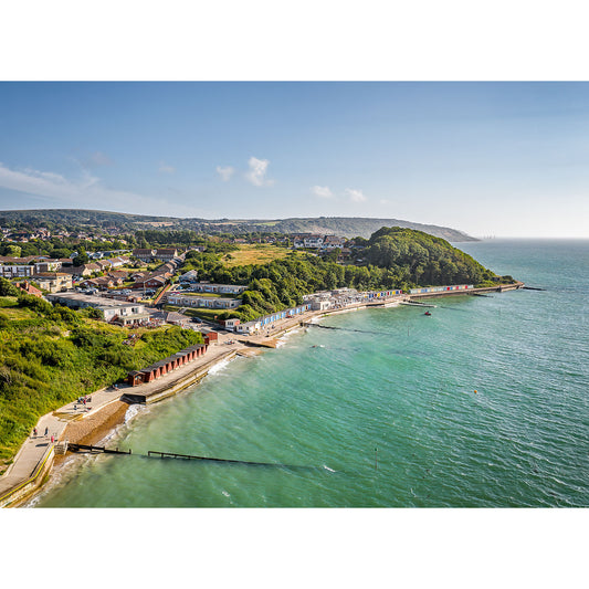 Aerial view of Colwell Bay, a coastal village with greenery, a beach, and clear waters on a sunny day on the Isle of Wight by Available Light Photography.
