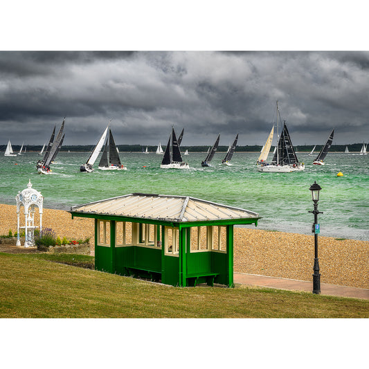Sailboats racing on a choppy sea under overcast skies, with a green seaside shelter on the Isle of Wight in the foreground captured by Available Light Photography during the Round the Island Race, Prince's Green, Cowes.