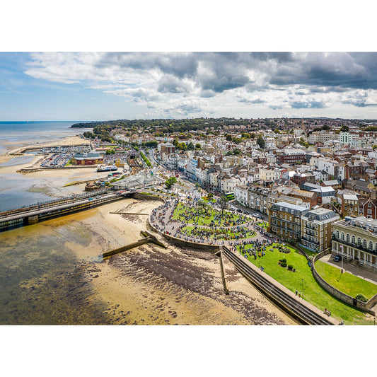 Aerial view of a coastal town on the Isle of Wight with a pier, beachfront, and densely packed buildings under a partly cloudy sky captured by Available Light Photography during The Isle of Wight Scooter Rally 2023.