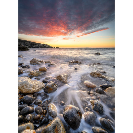 Sunset at a rocky beach with colorful skies and smooth water flow near Alum Bay & The Needles by Available Light Photography.