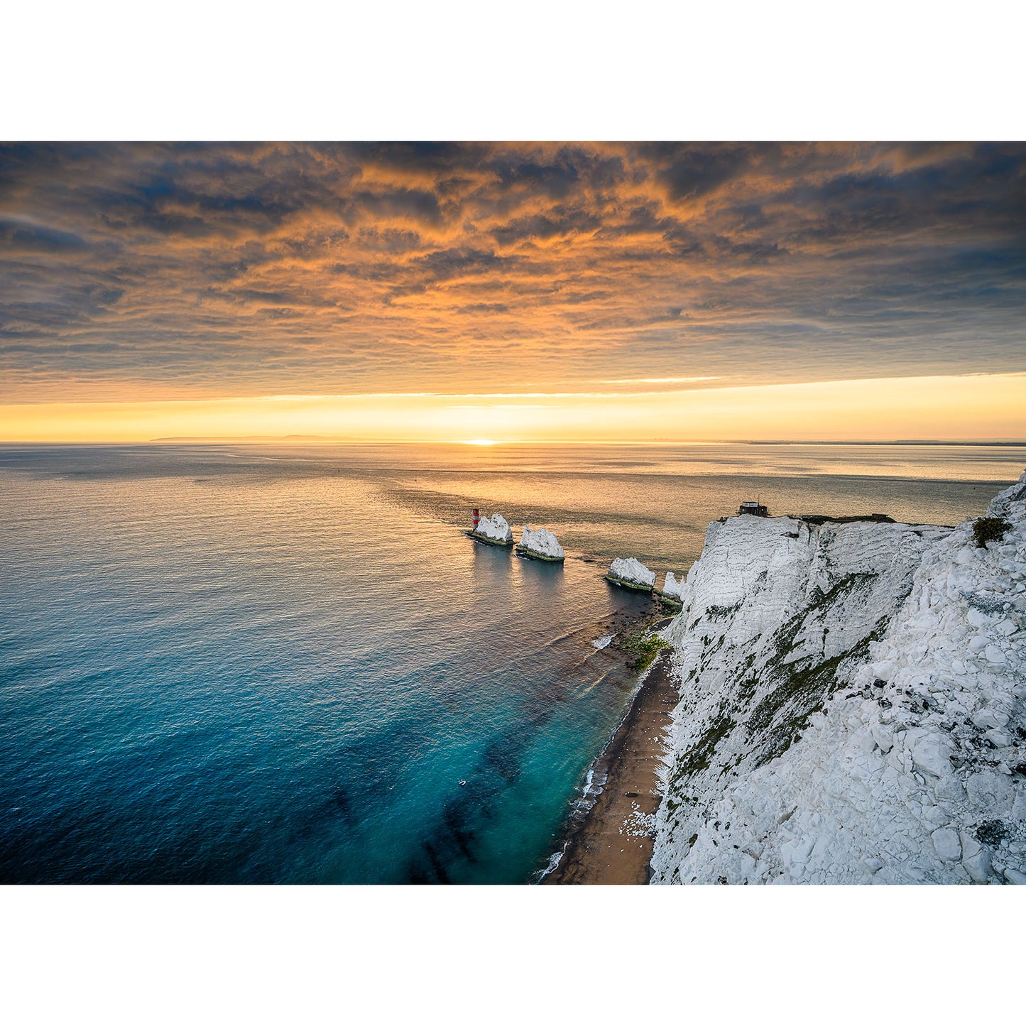 Sunset over a calm sea with white cliffs on the right and a ship near the coast under a cloudy sky captured by Available Light Photography. Image number: 2764 featuring The Needles.