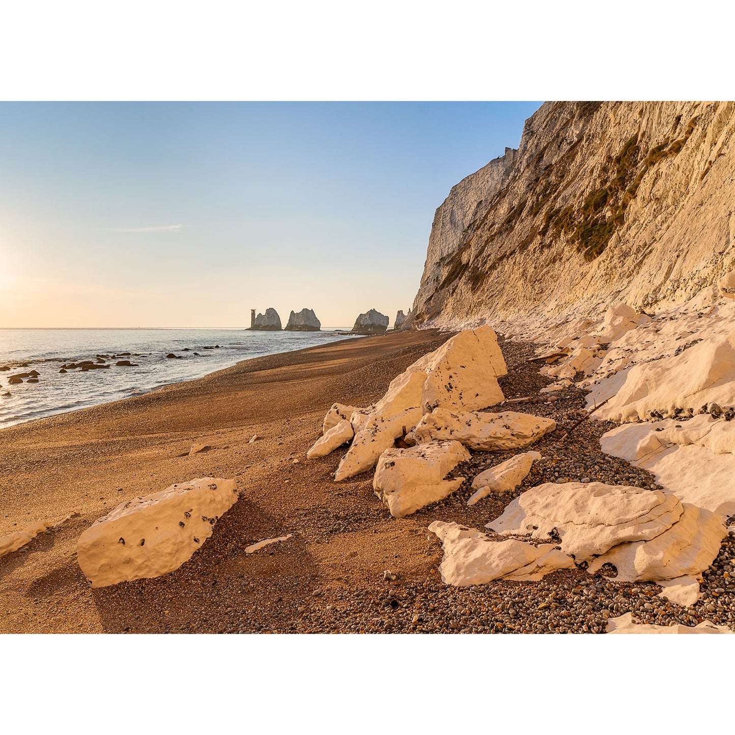 The Needles by Available Light Photography captures a rocky beach with towering white chalk cliffs on the right and a sunlit sea stretching to the left.