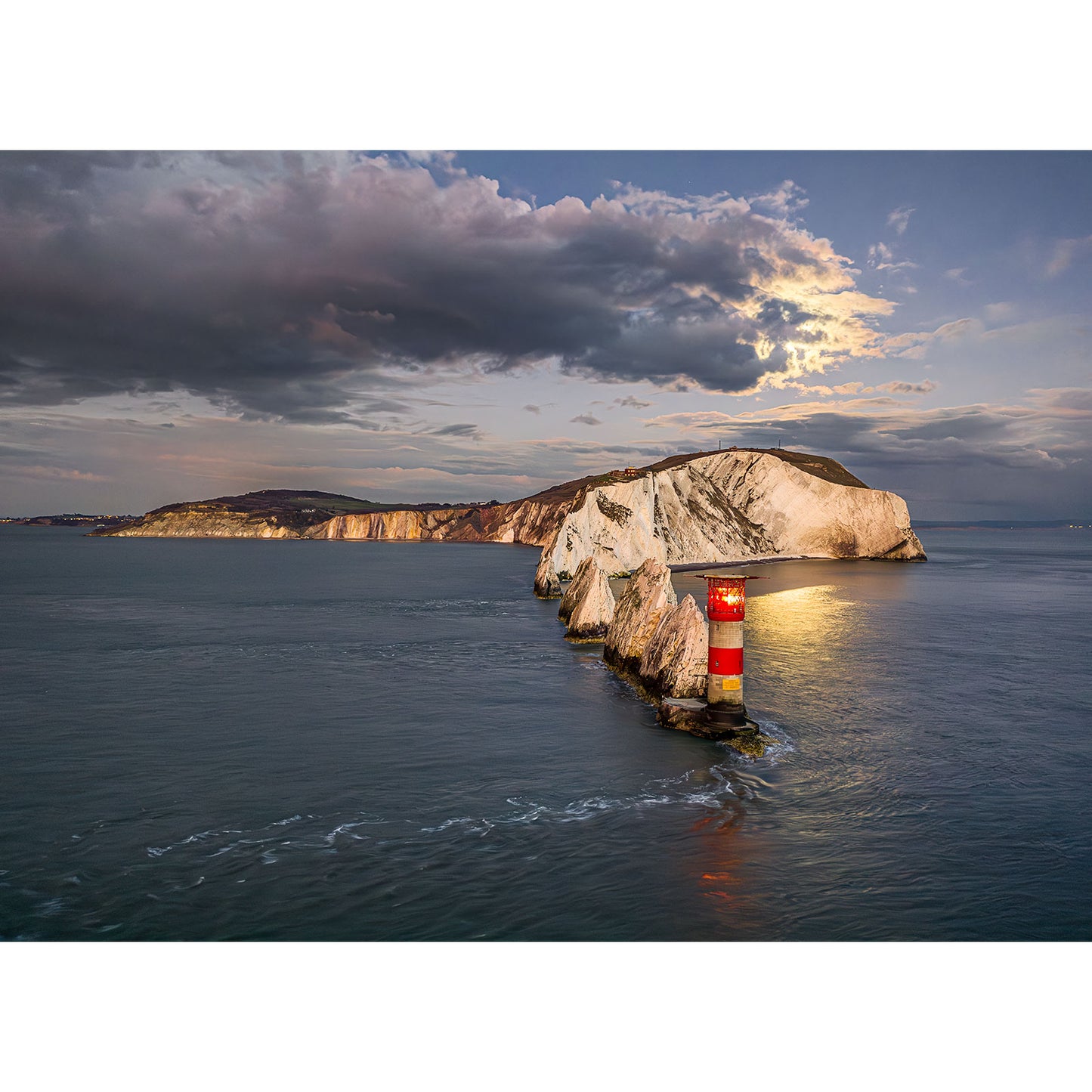 Moonrise over The Needles" by Available Light Photography captures a lighthouse on a rocky outcrop with the moon ascending against distant cliffs and a partly cloudy sky.