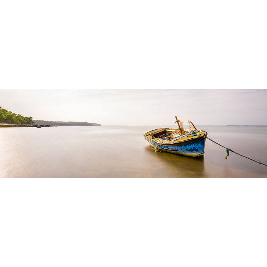 A weathered boat tethered on a tranquil shore with clear skies above, reminiscent of scenes Available Light Photography might encapsulate in his Woodside Bay paintings.