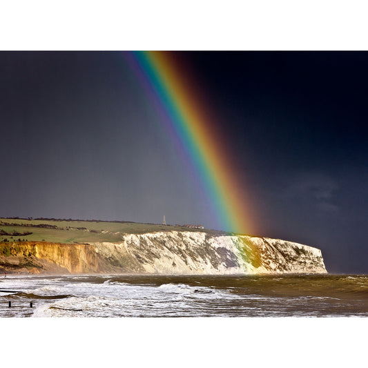 A vivid rainbow emerges above Culver Cliff coastline on Wight under a stormy sky, captured by Available Light Photography.