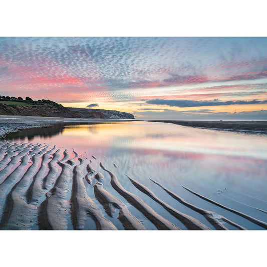 Sunset reflecting on a tidal flat with rippled sand patterns and a cloudy sky at Culver Cliff by Available Light Photography on the Isle of Wight.