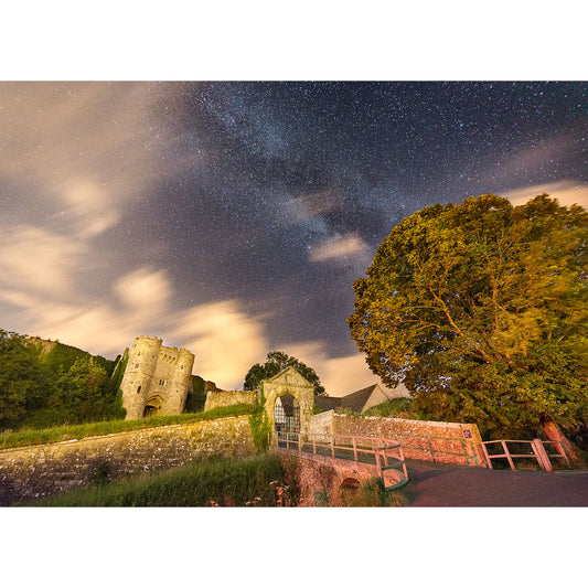 A nighttime scene with a Milky Way above Carisbrooke Castle on the Isle of Wight and a large tree, with part of the scene illuminated by ambient light taken by Available Light Photography.