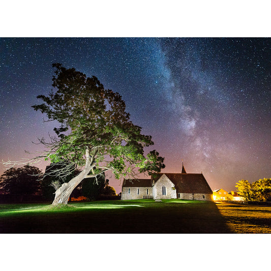 A nighttime scene of a church and tree on the Isle of Wight under a starry sky with the Milky Way visible, captured by Available Light Photography.