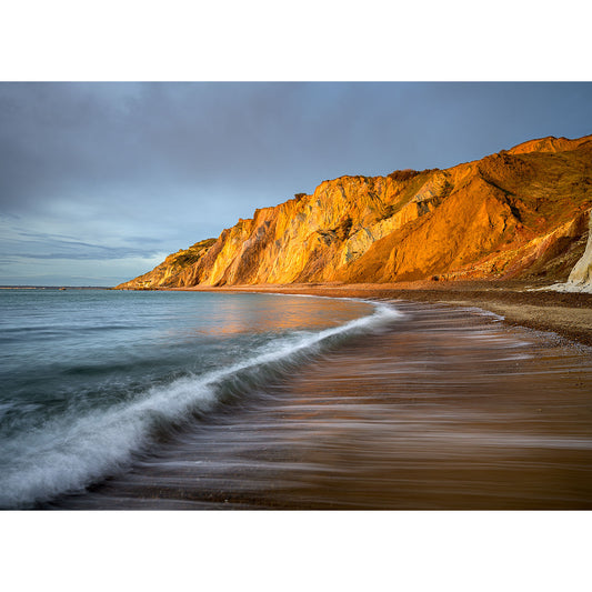 Golden Alum Bay sunlight illuminates the rugged cliffs by a serene beach on the Isle of Wight at sunset. - Available Light Photography