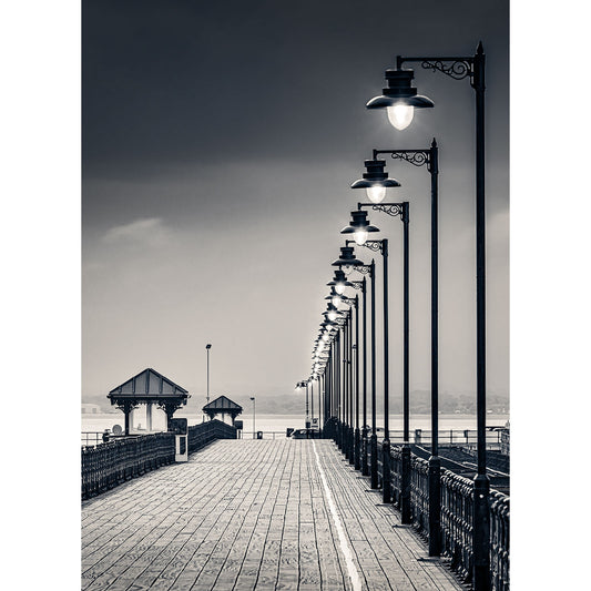 A row of Ryde Pier lamp posts lining a pier leading to a gazebo overlooking the water on Wight by Available Light Photography.