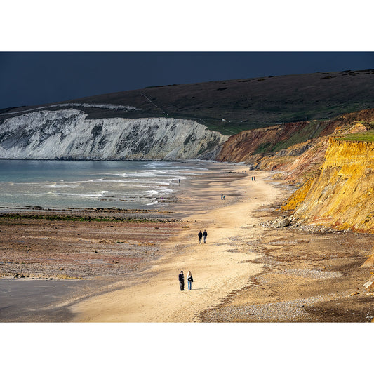 People walking on a beach with white cliffs on one side and Gascoigne cliffs on the other from Compton Bay by Available Light Photography.