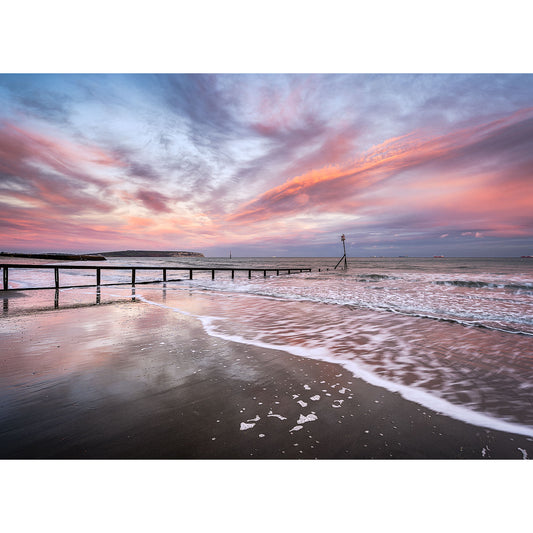 Sunset at a beach on the Isle of Wight with Culver Cliff from Shanklin and colorful clouds reflected on the wet sand by Available Light Photography.