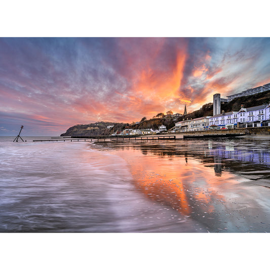 Sunset over Shanklin Beach with fiery clouds reflected in the wet beach sand, captured by Available Light Photography.