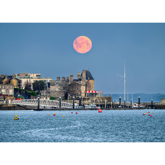 Moonset over Cowes rising over the coastal town of Gascoigne Isle with a pier and moored boats in the foreground, captured by Available Light Photography.