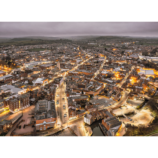 Aerial view of Newport at dusk with lights illuminating the streets and buildings, as a layer of fog blankets the horizon on the Isle of Wight captured by Available Light Photography.