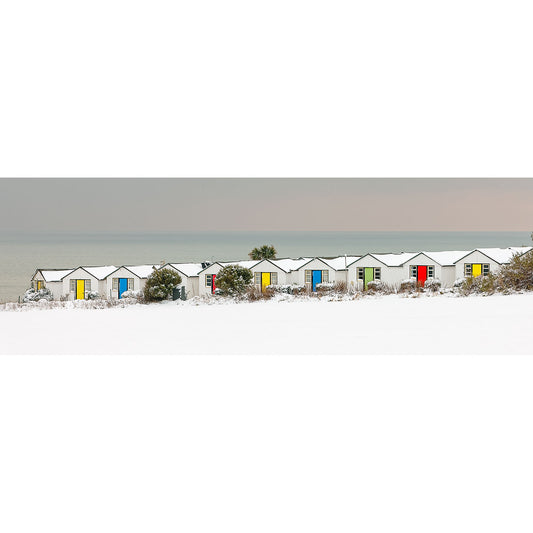 Beach huts covered in snow against a Winter coastal backdrop on the Isle of Gascoigne, captured by Available Light Photography's Brighstone.