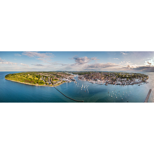A panoramic aerial view of Cowes and East Cowes, a coastal town with a bridge connecting the Isle of Wight to the mainland, dotted with boats in the harbor taken by Available Light Photography.