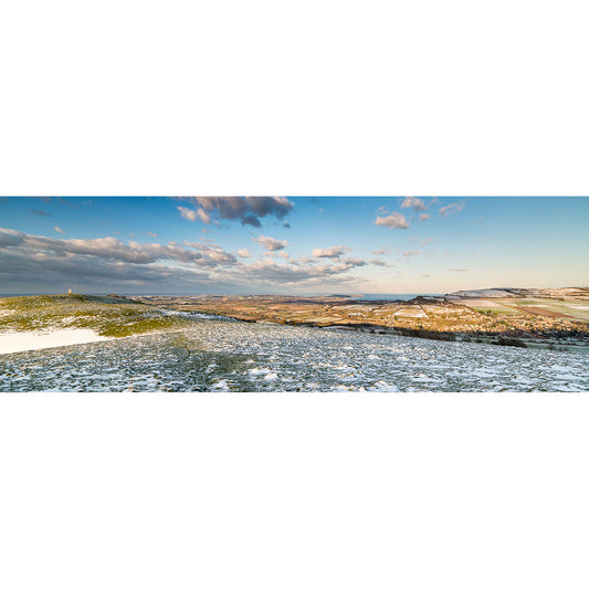 Wide panoramic view from Appuldurcombe Down: a frosty field with patches of snow beneath a blue sky and scattered clouds, distant hills on the horizon. Available Light Photography.
