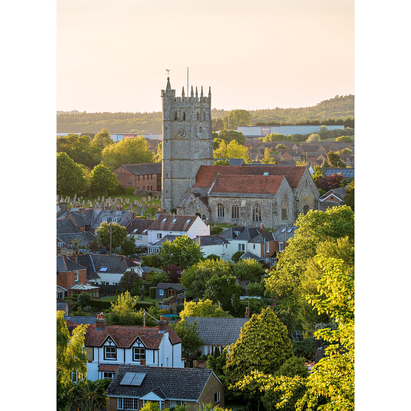 Sunset illuminating St. Mary's Church in Carisbrooke on the Isle of Wight captured beautifully by Available Light Photography, with a prominent church tower surrounded by lush greenery.
