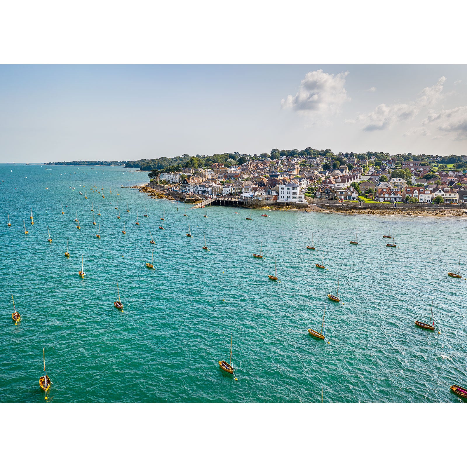 Aerial view of a coastal town on the Isle of Wight with moored boats and clear blue waters captured by Seaview from Available Light Photography.
