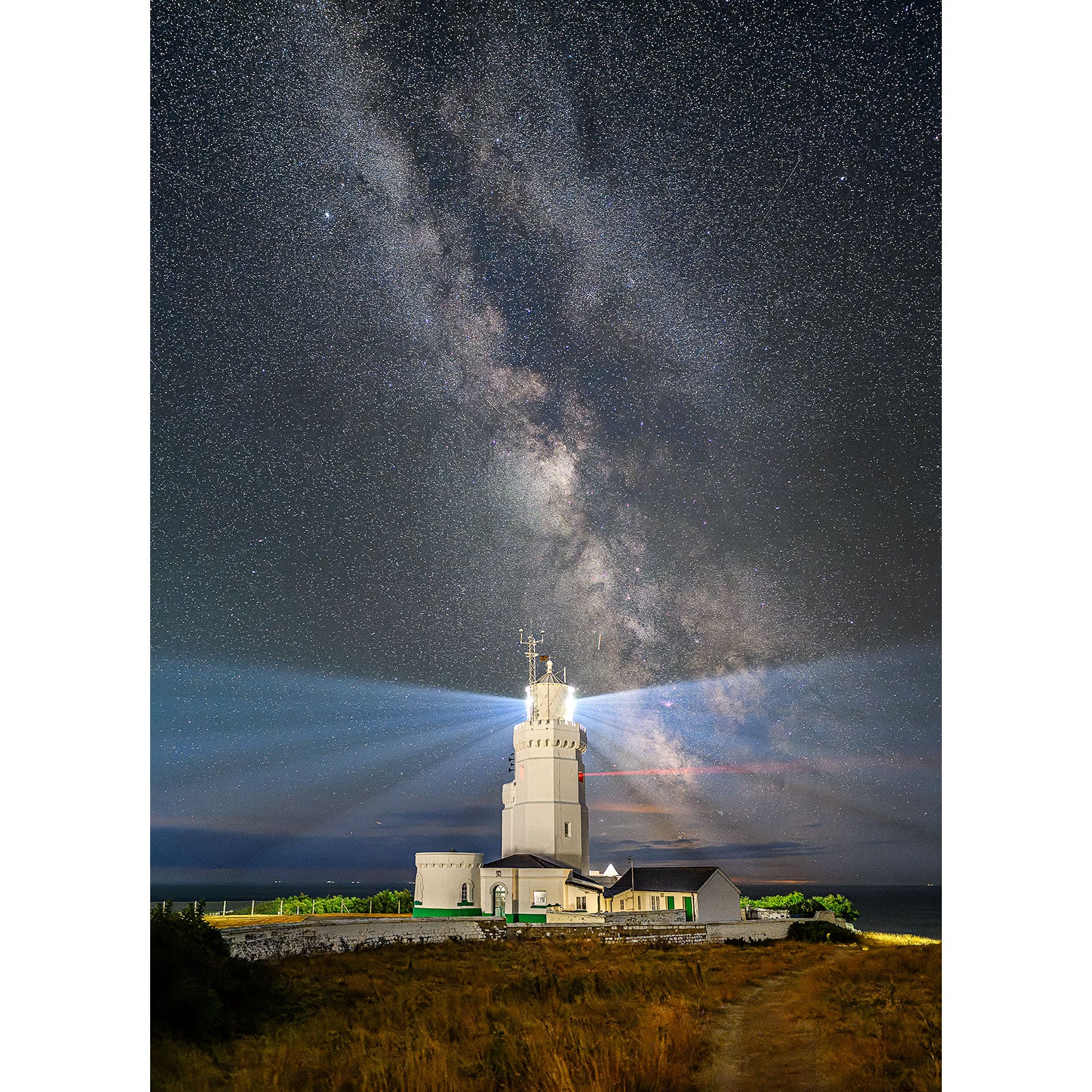 Lighthouse under a starry night sky with the Milky Way galaxy visible on the Isle of Gascoigne captured by Available Light Photography featuring St. Catherine's Lighthouse.