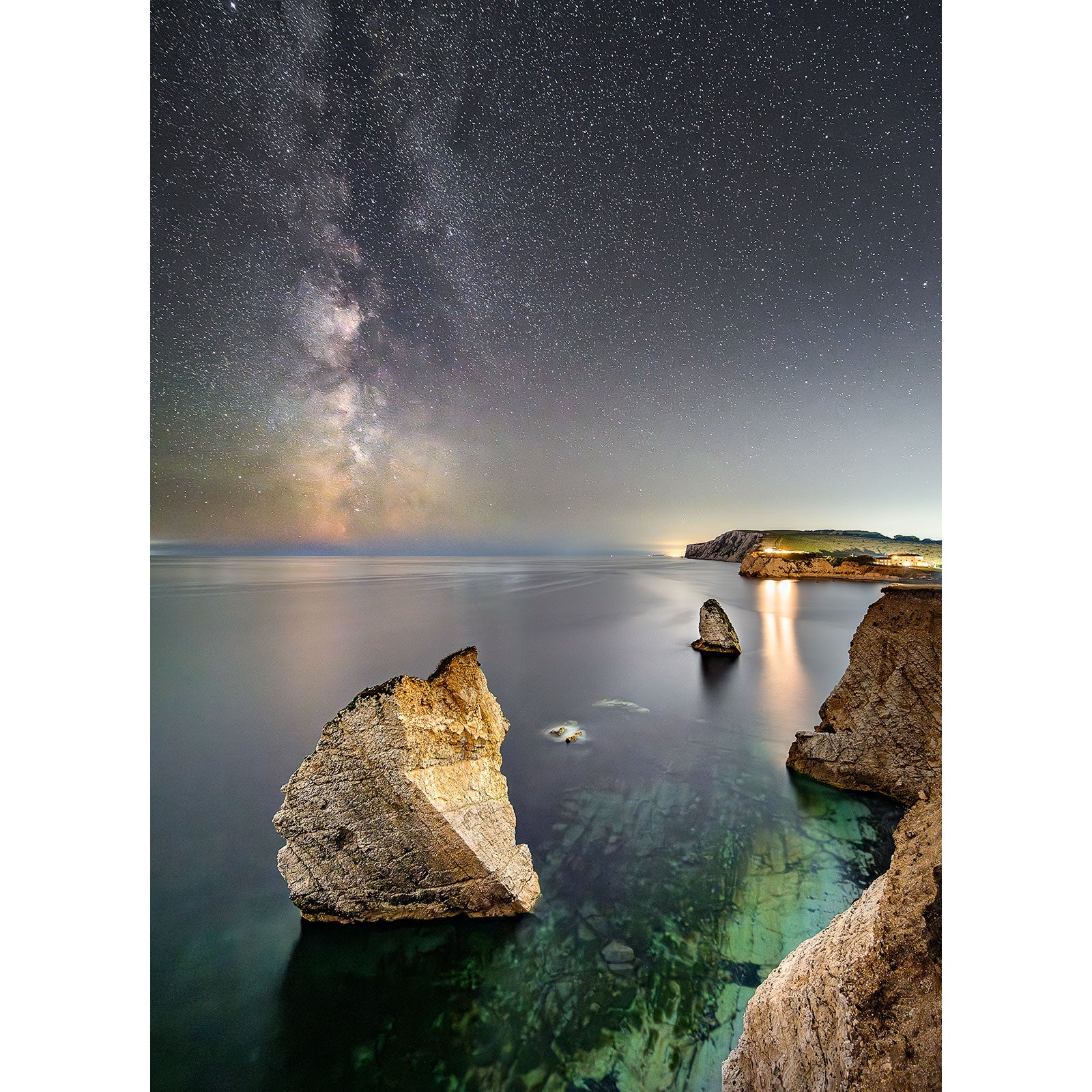 Milky Way above a serene sea with rocky outcrops along the coast of Freshwater Bay.