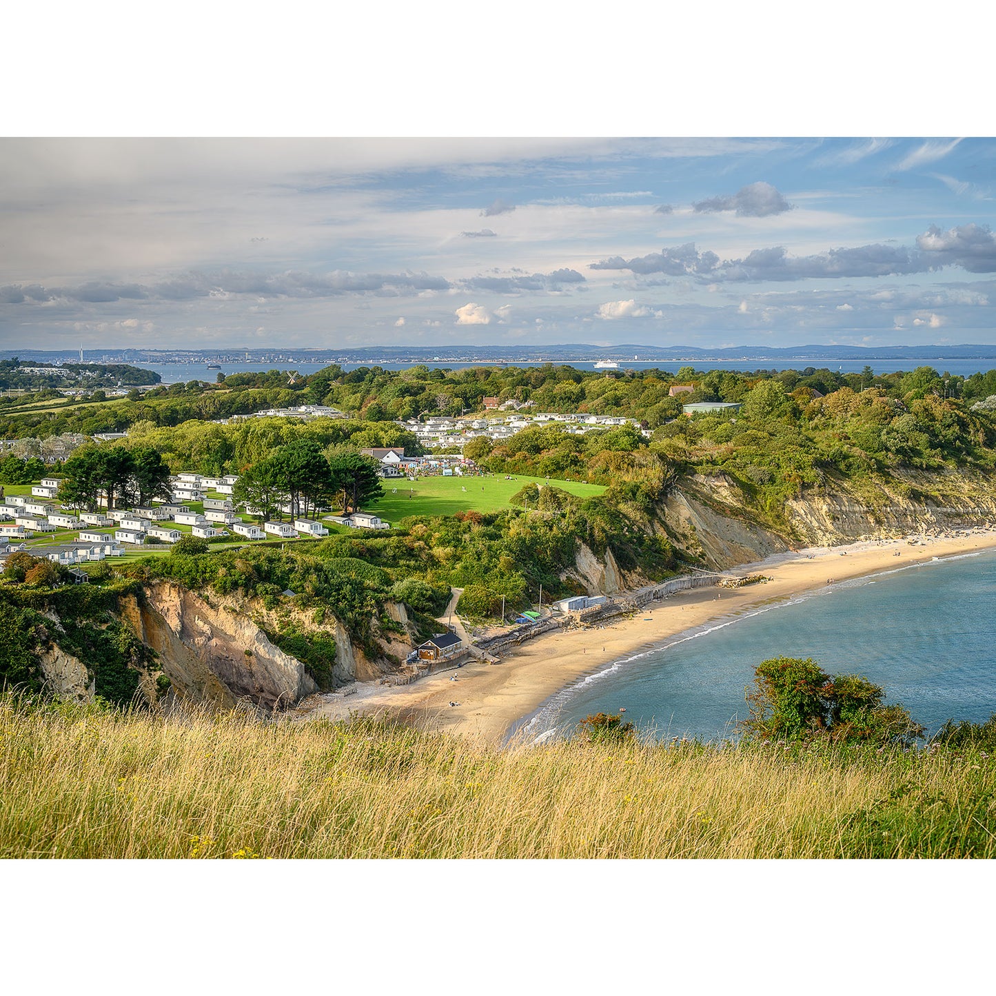 Coastal landscape featuring Whitecliff Bay beach with a caravan park overlooking the sea on the Isle of Wight, captured by Available Light Photography.