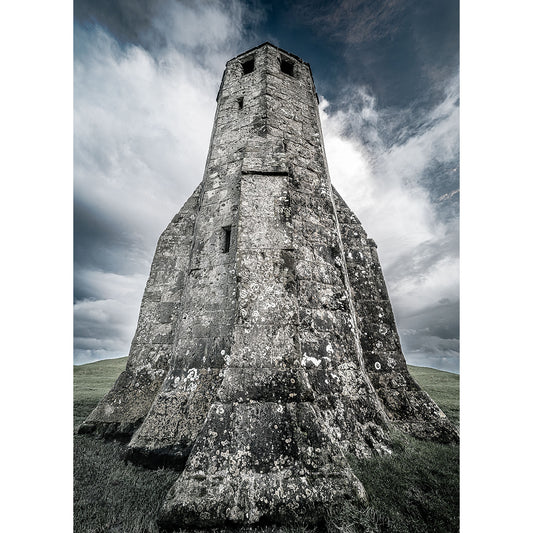 An ancient St. Catherine's Oratory stone tower stands tall against a dramatic sky, its weathered surface showing signs of age and exposure to the elements. Image 2821 captures this moment perfectly by Available Light Photography.