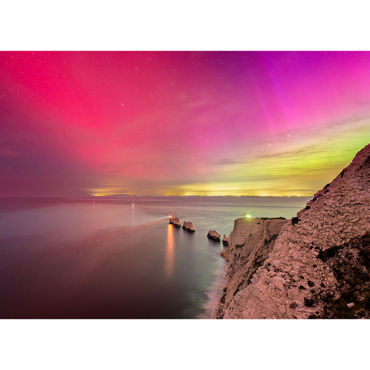 A vibrant The Northern Lights over The Needles, viewed from The Needles, with brilliant pink and green hues illuminating the night sky by Available Light Photography.