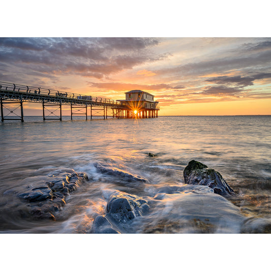 Totland Pier by Available Light Photography captures a stilted building at sunset, sunlight streaming through as waves roll in and clouds drift above—ideal for serene coastal escapes.