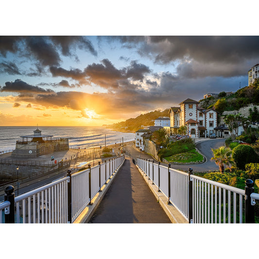 Image number 3094 from Available Light Photography features Ventnor’s paved walkway with white railings leading to the beach at sunset, historic buildings, and palm trees lining the right side.