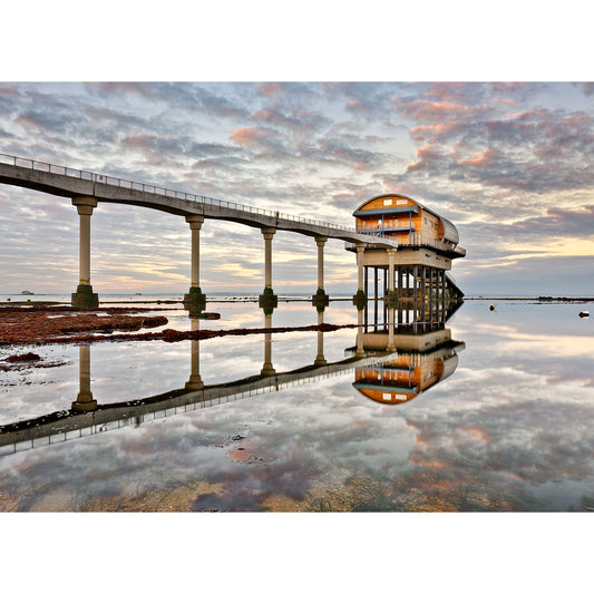 A pier with Bembridge Lifeboat Station, from Available Light Photography, at the end reflected on the calm water at sunset on the Isle of Wight.