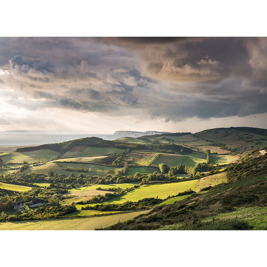 Rolling hills on the Isle of Wight bathed in sunlight with Incoming Storm by Brighstone clouds looming overhead. - Available Light Photography