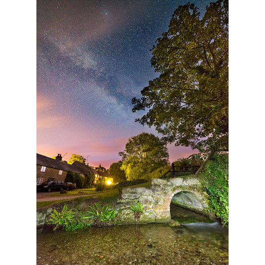 Starry Milky Way over a quaint stone bridge in a rural village on Winkle Street on the Isle of Wight, captured by Available Light Photography.