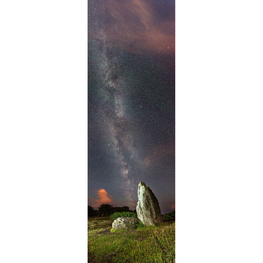 A standing stone under a starry night sky with the Milky Way visible over The Longstone, by Available Light Photography.