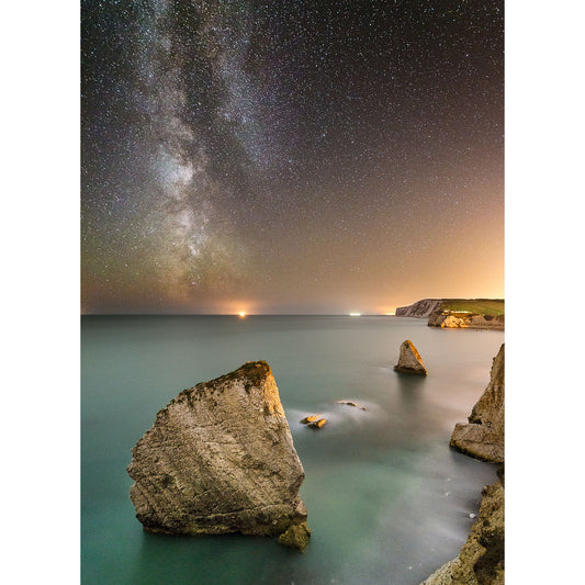 A night sky filled with stars and the Milky Way above a serene ocean with large rock formations reminiscent of the Isle of Wight.
Product Name: Freshwater Bay, Available Light Photography