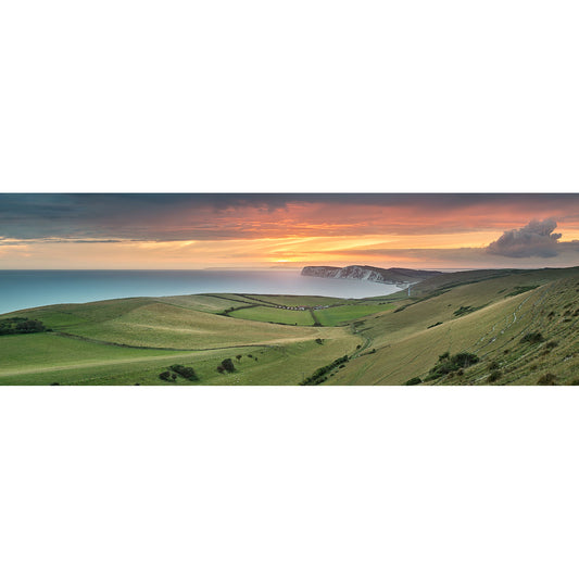 A panoramic view of rolling hills, a coastal landscape on the Isle of Wight, and a sunset captured in "Looking toward Tennyson Down" by Available Light Photography.