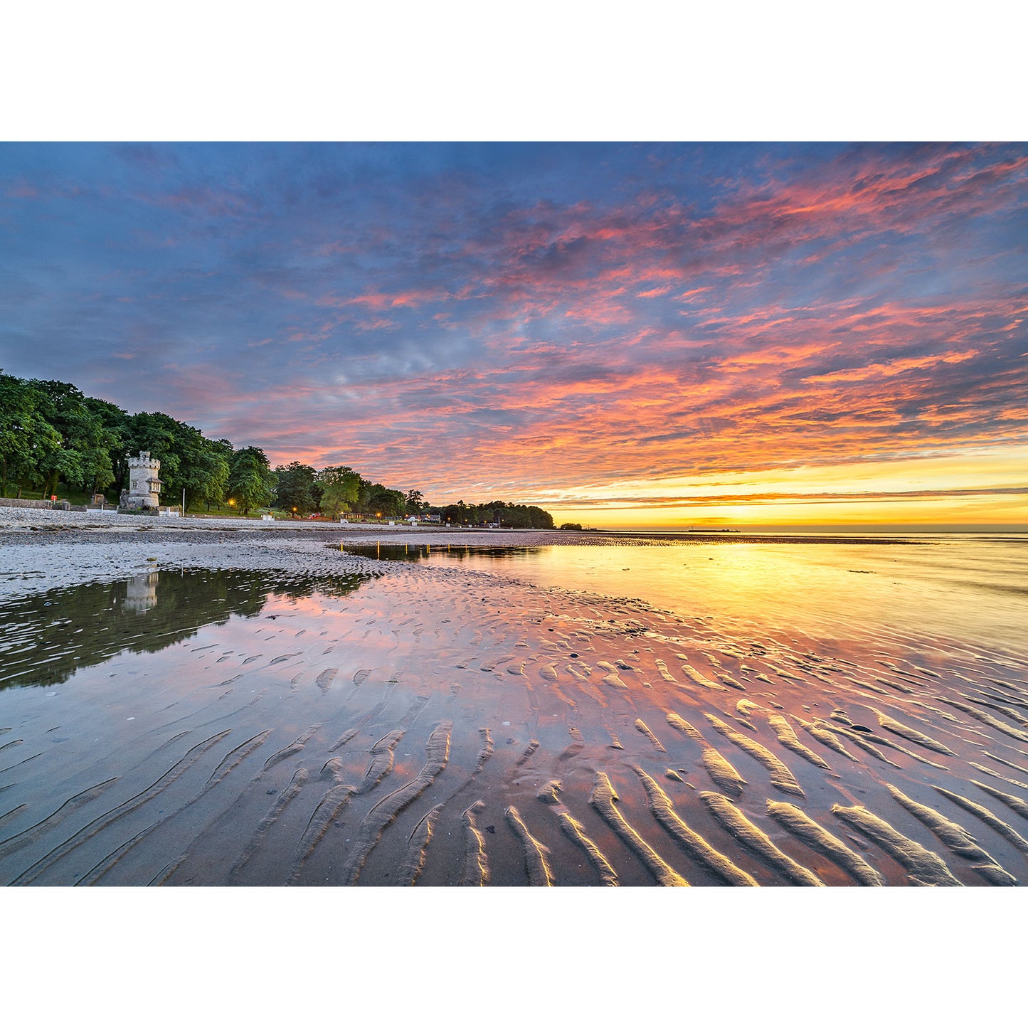 Sunset over the Appley Beach with colorful clouds and rippled sand by Available Light Photography.