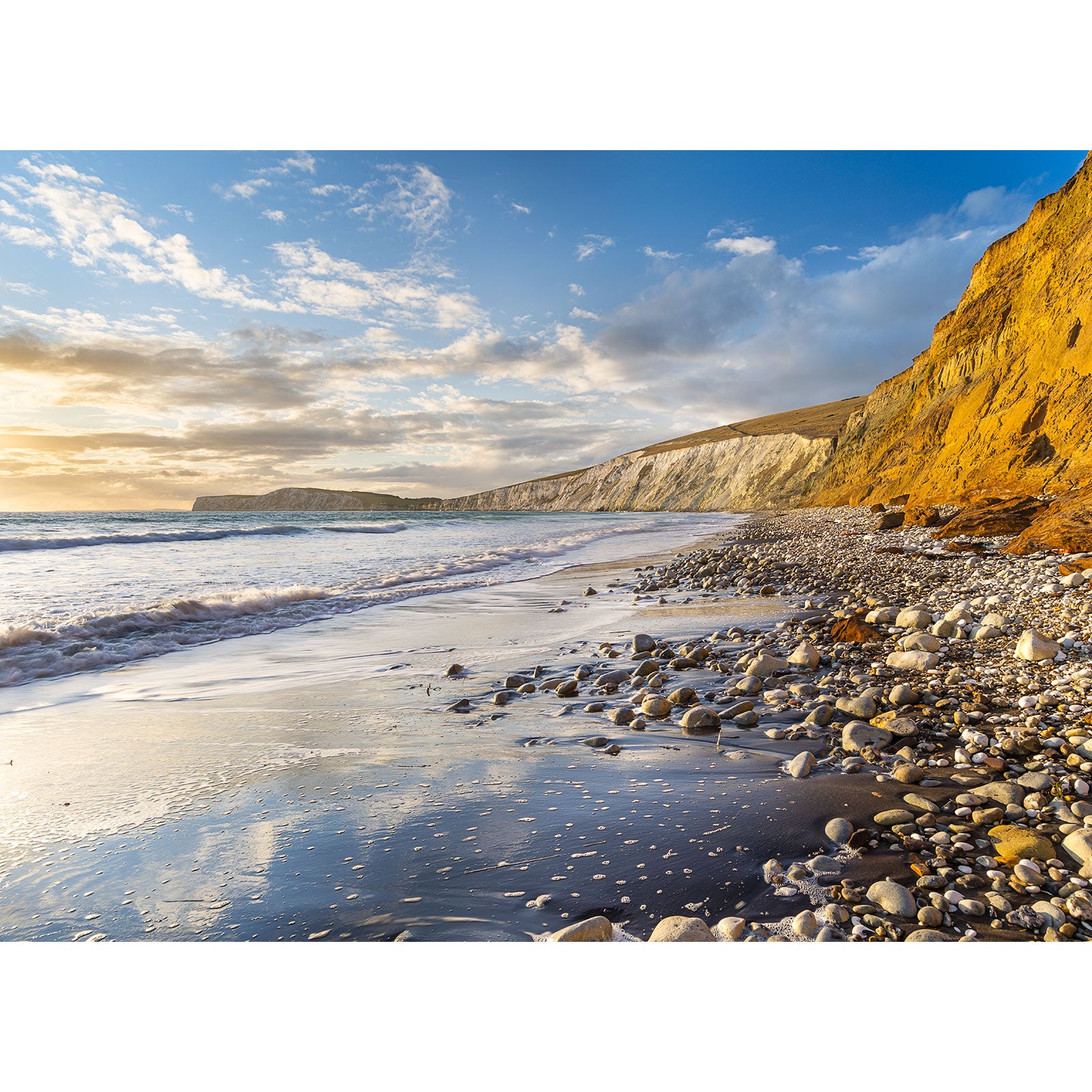 Sunset at Compton Bay, a pebbly beach with cliffs and reflective shoreline on the Isle of Wight by Available Light Photography.