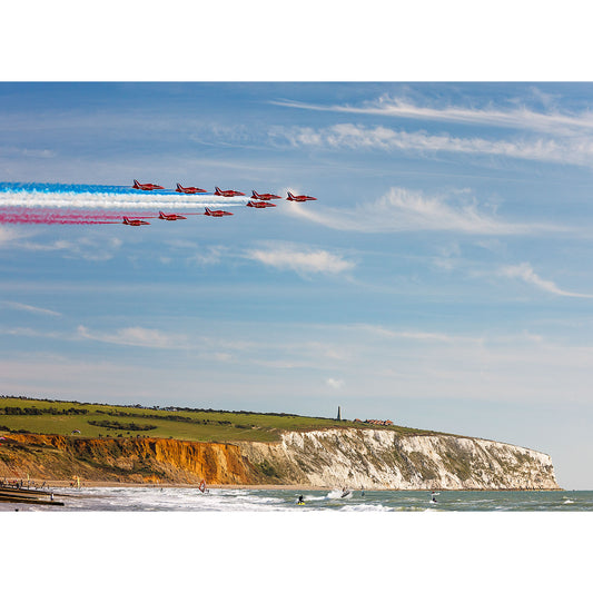 The Red Arrows, Culver Cliff aerobatic jets flying in formation with colored smoke trails over the Isle's coastal landscape captured by Available Light Photography.