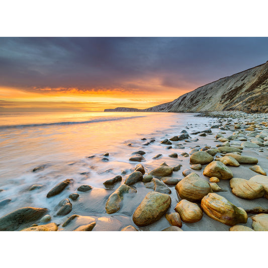 Sunset over Compton Bay, a pebble-strewn beach on the Isle of Wight captured by Available Light Photography, with calm waves and a colorful sky.