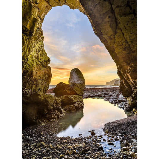 A serene coastal sunset on Freshwater Bay viewed from a cave with a natural archway, featuring a calm tide pool and rock formations captured by Available Light Photography.