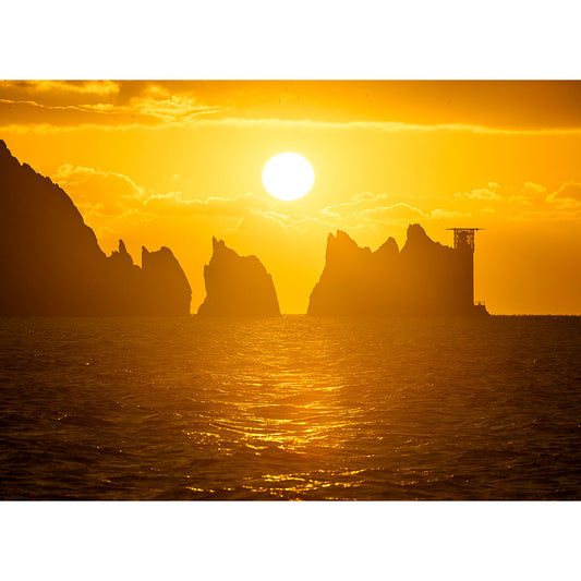 Sunset over the rugged coastline of Isle Gascoigne with silhouetted cliffs and a calm sea captured by The Needles from Available Light Photography.