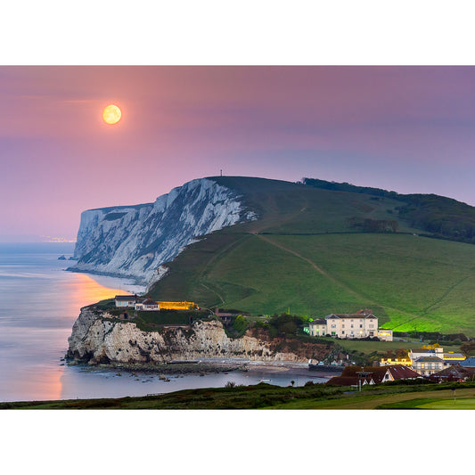 Moonset rising over white chalk cliffs by the sea at dusk on the Isle of Wight, captured by Available Light Photography.