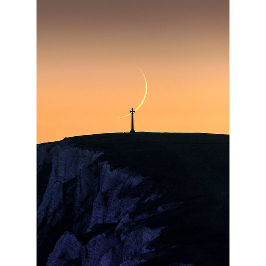 A person stands on a hilltop against a twilight sky with a Crescent Moon above, overlooking Tennyson Down on the Isle of Wight captured by Available Light Photography.